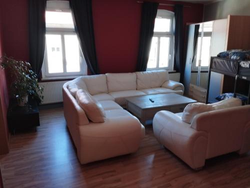 a living room with a white couch and a table at Stadtblick 2 Monteuerglück in Eisenberg