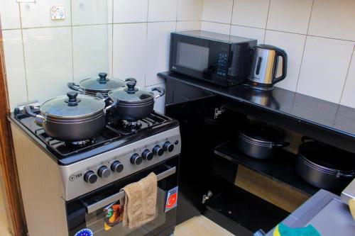 a kitchen with two pots on top of a stove at POPPI HOUSE 3 bedroom in Kampala