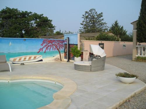 un patio con piscina, sedie e murale di Chambre d'hôtes à Usclas d'Hérault a Usclas-lʼHérault