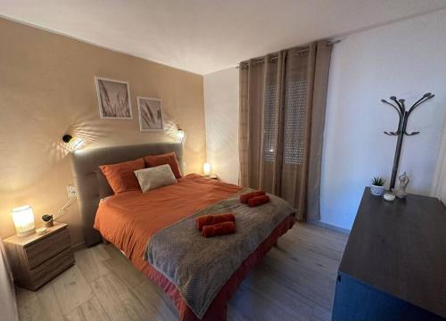 een slaapkamer met een bed met twee rode handdoeken erop bij centre de Thuir appart cosy in Thuir