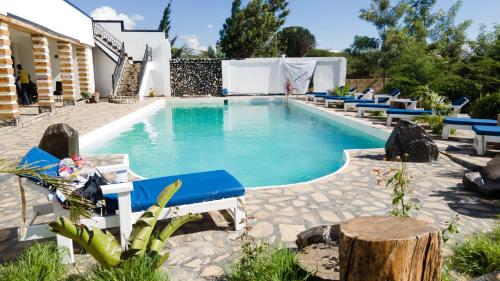 ein Pool mit blauen Liegestühlen um ihn herum in der Unterkunft Lakewood city Resort in Narok