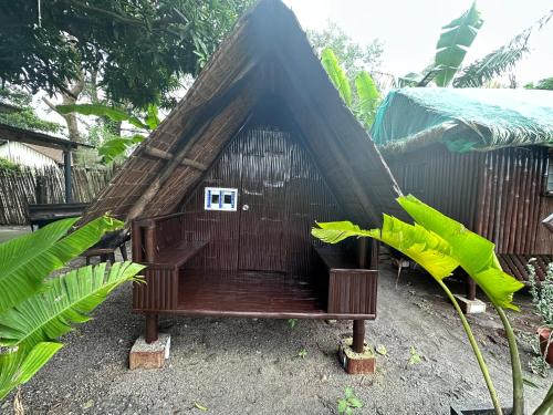 una pequeña casa con techo de paja en Camp Binoclutan Kubotel en Botolan