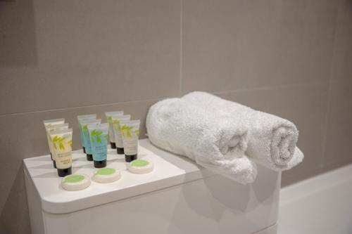 a bathroom with a towel and a shelf with toothbrushes at Charming One-Bedroom Retreat in Kingston KT2, London in Kingston upon Thames