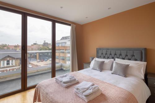 a bedroom with a bed and a large window at Charming One-Bedroom Retreat in Kingston KT2, London in Kingston upon Thames