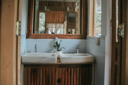 a bathroom with two sinks and a mirror at AROMA HOUSE - Private entire house on Cat Ba island in Cat Ba