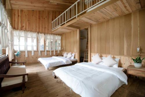 a bedroom with two beds and a loft at AROMA HOUSE - Private entire house on Cat Ba island in Cat Ba