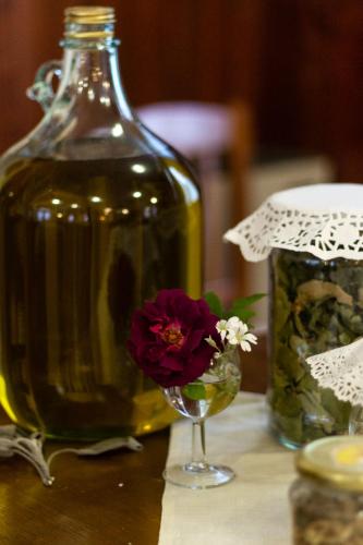 a flower in a wine glass next to a bottle at Albergo Santo Spirito in Molini di Triora