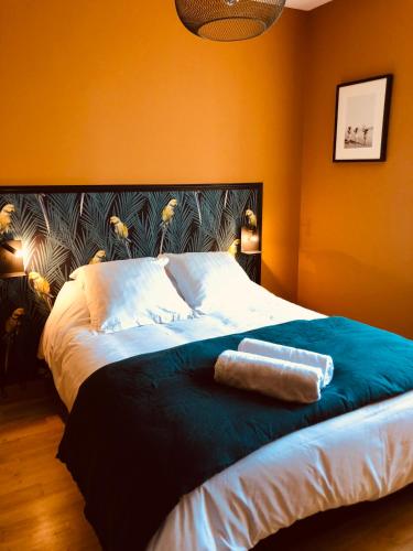 une chambre avec un grand lit aux murs orange dans l'établissement Appart's Casa Mina, à Saint-Malo