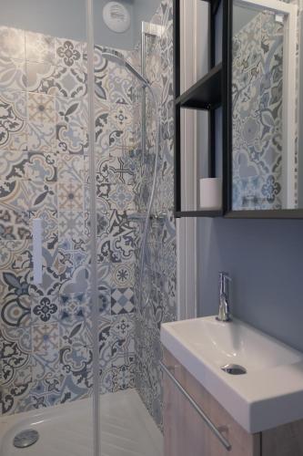 une salle de bain avec une douche en verre avec un lavabo dans l'établissement Appart's Casa Mina, à Saint-Malo