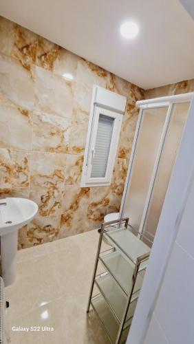 a bathroom with a chair and a sink at VIVIENDA MELIBEA in La Puebla de Montalbán