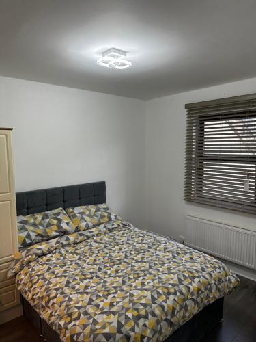 a bedroom with a bed with a comforter and a window at Cosy Room in Shannon