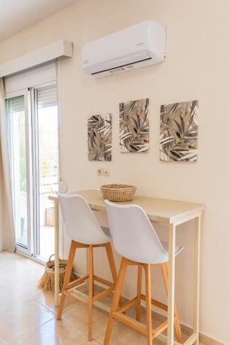 a dining room with a table and white chairs at Casa Calida - 500m to Kos Town in Kaká Pinári