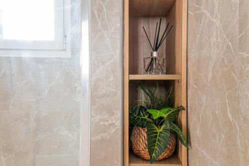 a wooden shelf with two plants in a bathroom at Casa Calida - 500m to Kos Town in Kaká Pinári