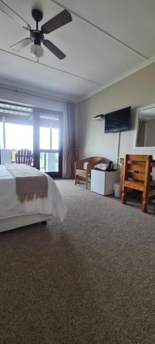 a bedroom with a bed and a flat screen tv at Greystone Guesthouse in Jeffreys Bay