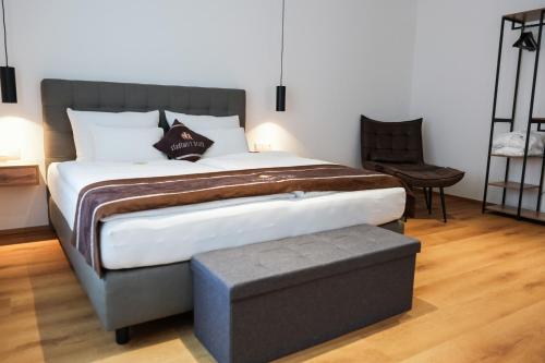 uma cama grande num quarto com uma cadeira em stadtwirt bruck em Vöcklabruck