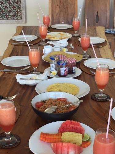een lange houten tafel met borden eten en drinken bij Villa Aamisha in Candidasa