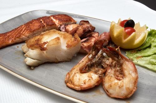 a plate of food with shrimp and vegetables on a table at Hotel Restaurant Doppeladler in Rees