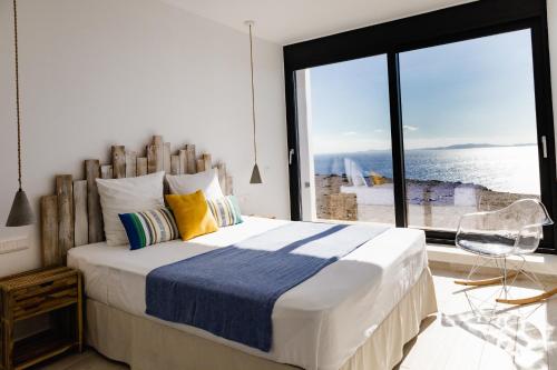 a bedroom with a large bed with a large window at Dream Cave Villa Tinos in Tinos Town