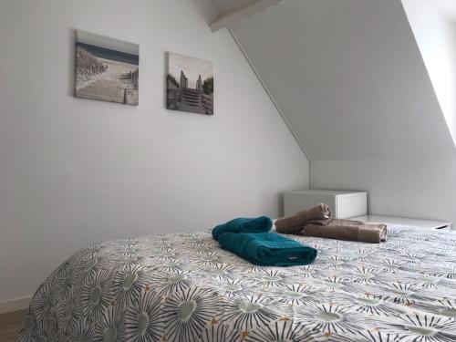 Bett mit blauer Decke auf einem Zimmer in der Unterkunft Maison Guerande La Baule in Guérande