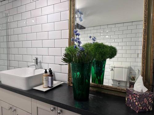 a bathroom with a sink and a vase with flowers at Characterful house in Hertford - near London in Hertford