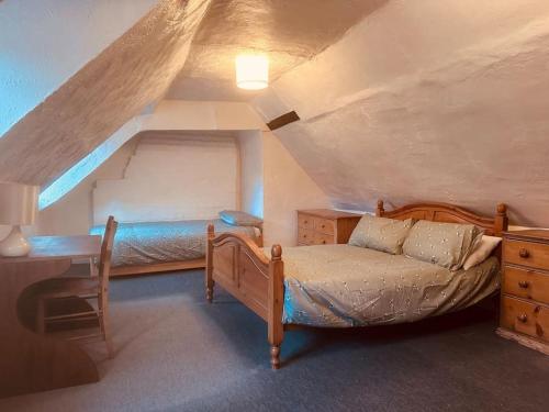 a bedroom with a bed and a desk in a attic at Characterful house in Hertford - near London in Hertford