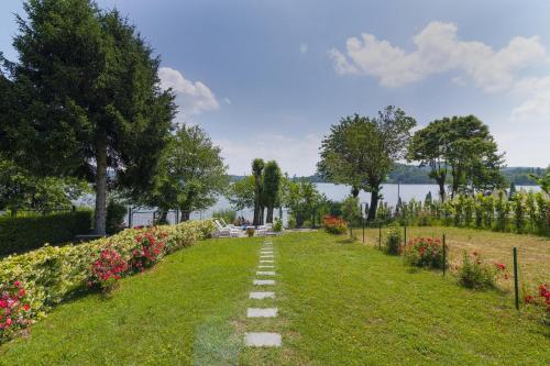ścieżka przez park z kwiatami i jeziorem w obiekcie Casa Maddalena Private Beach on request - Happy Rentals w mieście Cadrezzate