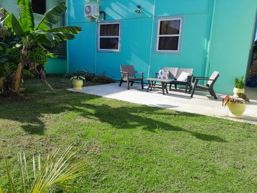 a blue building with two chairs and a table at Comfi Spaces in Canaan