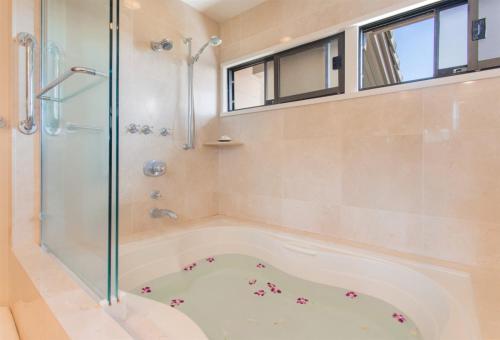 a bathroom with a shower and a tub at 622 Kapalua Ridge Villa in Kahana