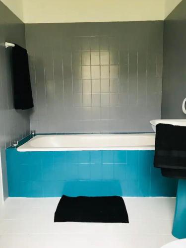 une baignoire bleue et blanche dans une salle de bain dans l'établissement Gîte Au Boom Coeur - forfait SPA inclus, à Tourtenay