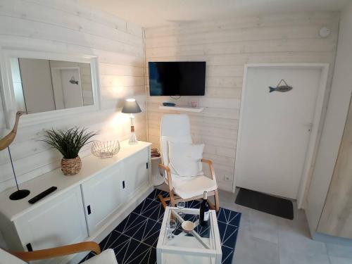 - un salon avec une armoire blanche et un miroir dans l'établissement Saint Georges de Didonne - LA PLAGE A 2 PAS - idéal pour un COUPLE avec ENFANTS, à Saint-Georges-de-Didonne