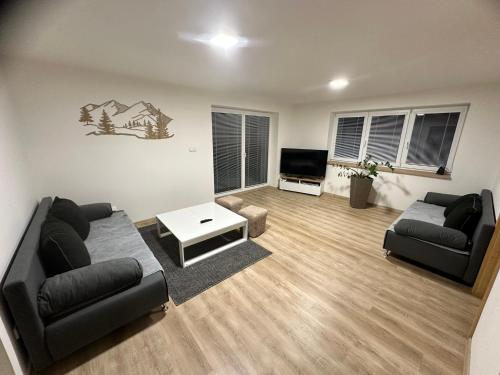 uma sala de estar com dois sofás e uma televisão em Chalupa Jarka em Jablŭnka