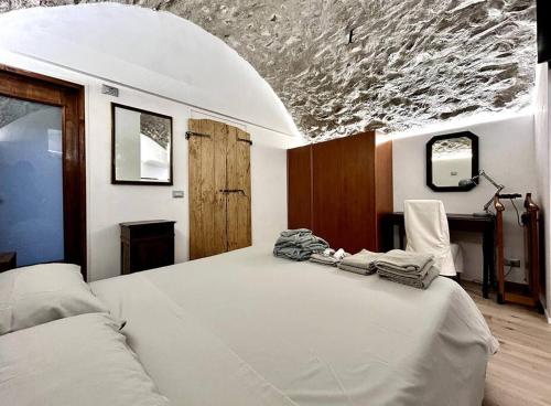 um quarto com uma grande cama branca com toalhas em Rifugio di Losine - Relax - Natura - Wi-Fi em Esine