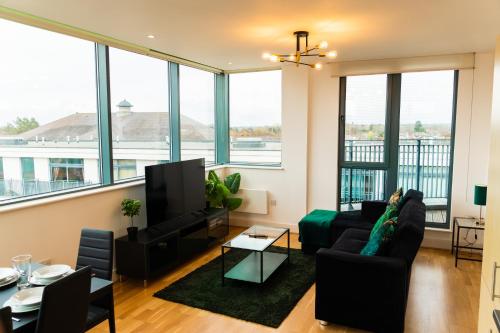 uma sala de estar com um sofá e uma televisão em The Regency Suite - Modern 2-Bed 1-Bath Apartment em Chertsey
