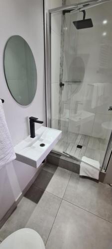 a bathroom with a sink and a shower at Greystone Guesthouse in Jeffreys Bay