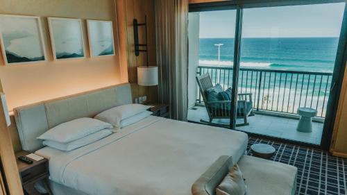 a bedroom with a bed and a balcony with the ocean at Grand Hyatt Rio de Janeiro in Rio de Janeiro