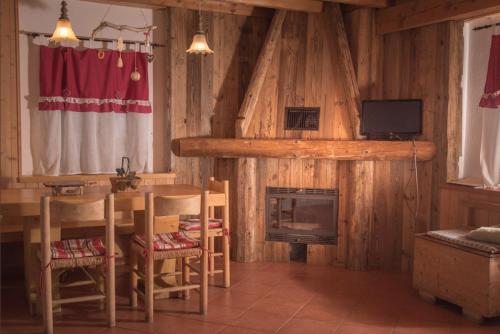 a living room with a table and a fireplace at Chalet Beatrice in Ledro