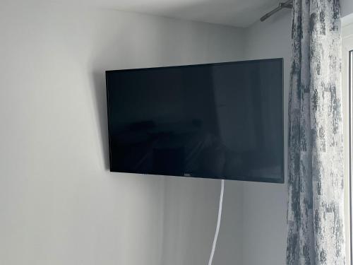 a flat screen tv hanging on a wall at Seaside Marine First Floor Apartment in Ballycastle