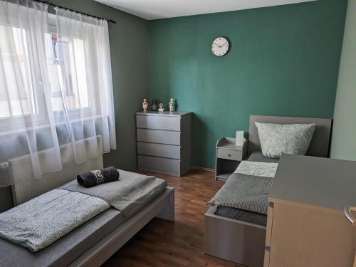 1 dormitorio con 2 camas y reloj en la pared en FeWo Lorenz, en Buchen