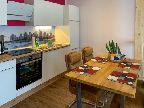 a kitchen with a wooden table with chairs and an oven at Top-moderne Ferienwohnung auf früherem wunderschönen Bauernhof im Elbe-Elster-Kreis in Süd-Brandenburg in Schönewalde