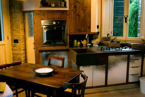 een keuken met een tafel en een fornuis top oven bij La casina-Maisonette in Serramazzoni