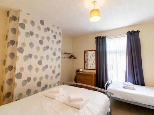 a bedroom with two beds and a window at Pass the Keys Comfortable townhouse a few miles from Durham City in Ferryhill