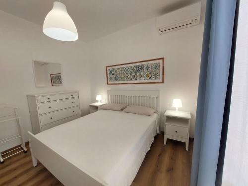 una camera con un letto bianco e due comodini di Cortile 5 Menfi a Menfi