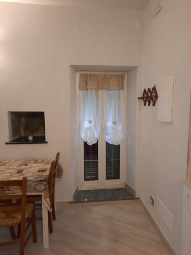 a dining room with a table and a door with curtains at Agriturismo del Ponte Monolocale "Anna" in Rialto