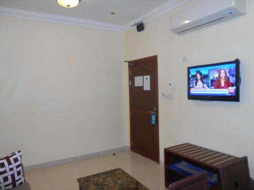a living room with a tv on the wall at Nizwa Hotel Apartments in Nizwa