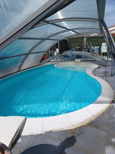 - une vue sur la piscine avec un toit extensible dans l'établissement chambre d'hôte indépendante, à Barzan