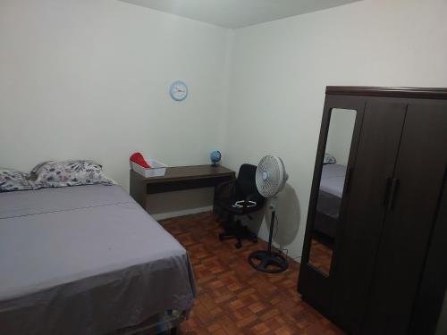 1 dormitorio con cama, tocador y espejo en Cómodo apartamento, en Amatitlán