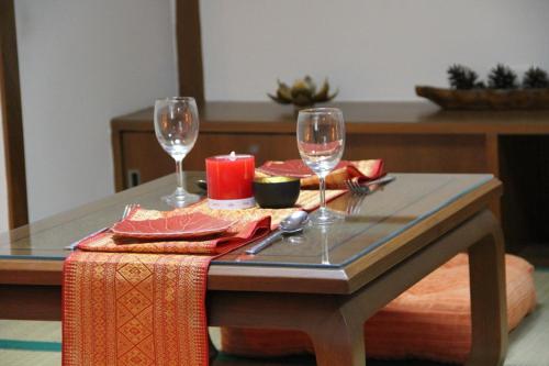 فندق بي إس كورت ساتورن في بانكوك: طاولة مع كأسين من النبيذ فوقها