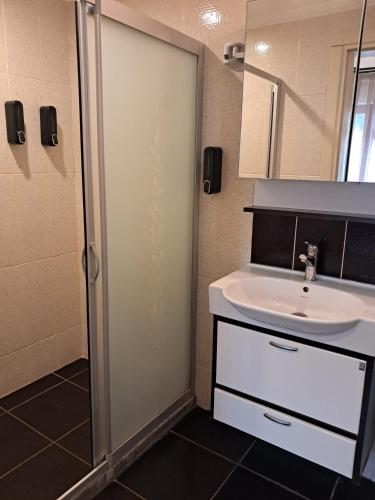 a bathroom with a white sink and a shower at Sözer Otel in Ayvalık