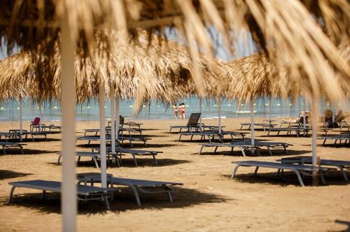 a group of chairs and umbrellas on a beach at Sea Breeze Resort, Lighthouse2 seaside studio apartment in Baku