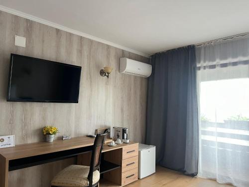 a room with a desk and a television on a wall at Hanu lu Mos Opinca in Deva